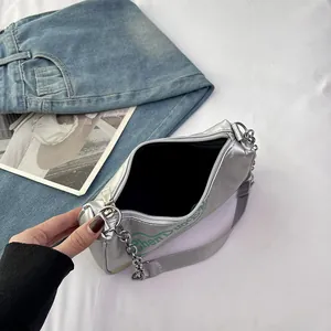 Borsa a spalla argentata a mezzaluna con finitura metallizzata e stampa graffiti