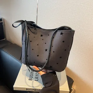 Dark gray tote bag with black star patterns and decorative ribbon on the shoulder strap