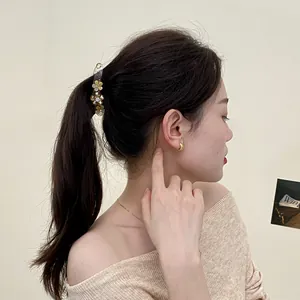 Floral rhinestone banana clip and gold hoop earrings set on model