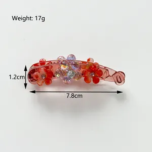 Amber translucent banana hair clip with five-petal flower and sparkling rhinestone details