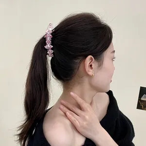 Pink floral banana hair clip with crystals on female ponytail for elegant hair styling