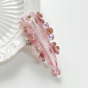 Detail of pink translucent banana hair clip with floral beads and shiny crystals