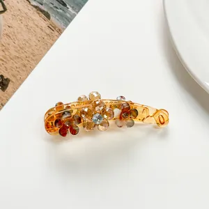 Detailed close-up of amber flower banana hair clip with sparkling rhinestones