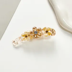 Detail of banana hair clip featuring sparkling crystal flowers and champagne petals