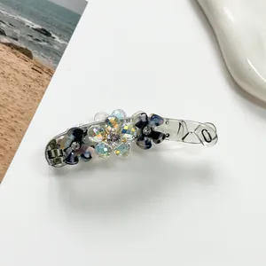 Macro detail of elegant banana clip featuring blue marble flowers and crystal beads
