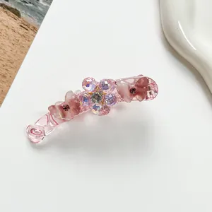 Vue détaillée de la pince banane rose avec fleurs en cristal et motifs papillons brillants