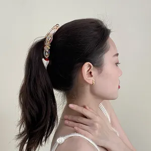 Elegant amber resin banana clip with floral rhinestones worn on a ponytail style