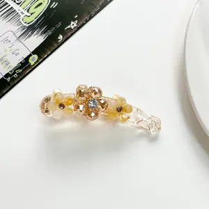 Detailed shot of banana clip with champagne resin flowers and sparkling rhinestone center