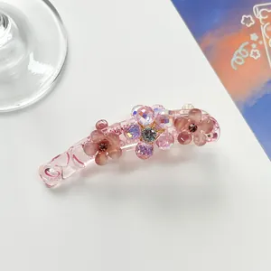 Detail of pink banana clip featuring matte flower petals and sparkling rhinestones