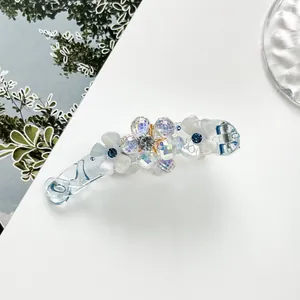 Detail of banana hair clip with blue crystal flowers and iridescent faceted beads