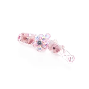 Pince à cheveux banane en résine rose avec fleurs en cristal et détails papillon violets