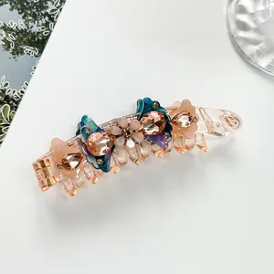 Detail of acetate banana hair clip featuring champagne floral crystal embellishments