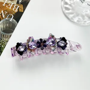 Detail of purple acetate banana clip with sparkling crystals and floral embellishments