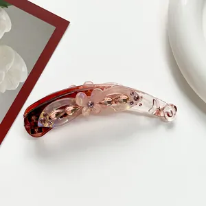 Detail of banana hair clip with pink gradient finish and frosted flower with rhinestones