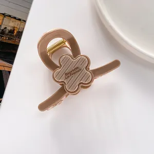 Vue macro d'une pince à cheveux de 7cm beige avec fleur et texte Barrette La France