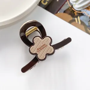 Détail d'une pince à cheveux de 7 cm en résine avec fleur beige et lettrage français