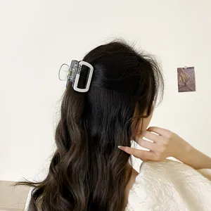 Pince à cheveux carrée avec strass gris foncé et blanc pour chignon élégant de femme