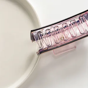 Detail of translucent gradient pink-purple hair claw clip with sharp teeth and metal spring