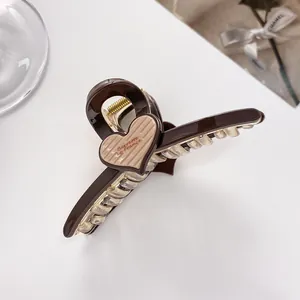 Detailed close-up of dark brown hair claw clip with beige heart and Barrette La France text
