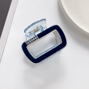 Détail de la pince à cheveux en acrylique bleu marine avec strass bleus sur le côté