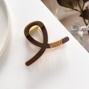 Detailed view of deep brown hair claw clip with rose gold frame and inlaid rhinestones