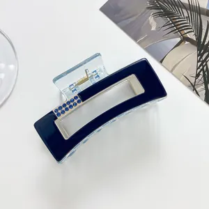Detailed view of a navy blue hair claw clip with sparkling light blue rhinestones