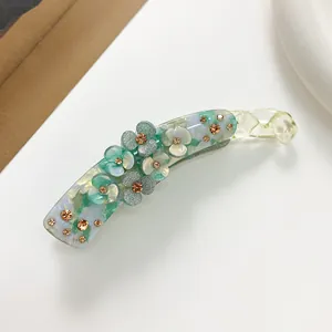 Macro shot of large banana clip with resin flowers and sparkling rhinestones