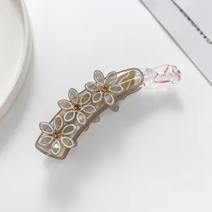 Detailansicht der glitzernden Blumen-Bananenspange mit funkelnden bernsteinfarbenen Steinen