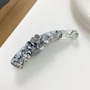 Detail of grey-blue marble banana hair clip with 3D flowers and sparkling rhinestones