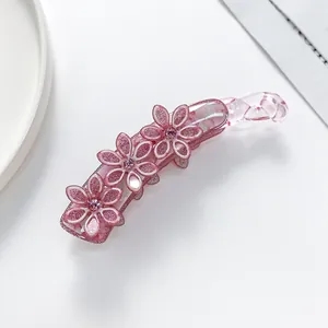 Makroaufnahme von glitzernden rosa Blumen mit Strass auf einer Bananen-Haarklammer