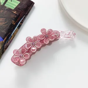 Dettaglio di un fermaglio a banana rosa in resina con glitter e fiori in strass lucidi