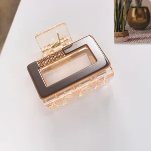 Detailed macro view of square amber resin hair claw clip with rhinestones