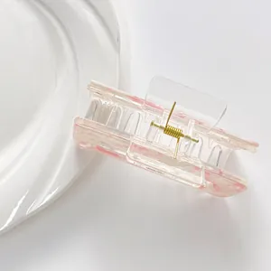 Pink marble pattern acrylic hair claw clip with golden spring on a white background