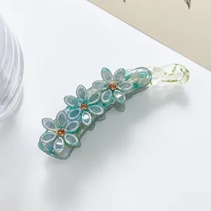 Detailaufnahme der blauen Glitzer-Blumen-Haarklammer mit bernsteinfarbenen Strasssteinen