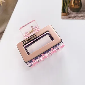Detail of square hair claw with rhinestones, rose gold finish, and pink clear plastic