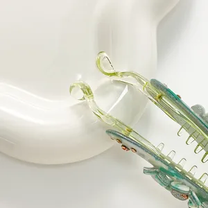 Floral banana hair claw clip in translucent green and orange for thick hair styling