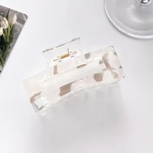 Detail of a rectangular marble texture hair claw clip made of beige acrylic resin