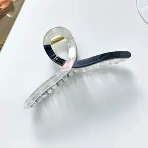 Detail of extra large hair claw clip with colorful resin and golden metal spring