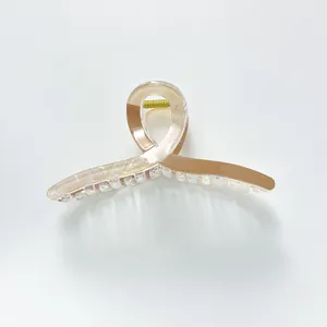 Detail of extra large hair claw clip with pearlescent beige and brown mosaic texture