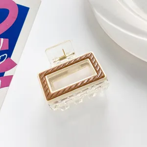 Detail of a rectangular striped hair claw clip with cream frame and brown texture