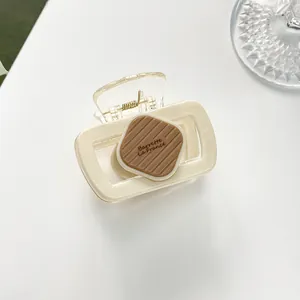 Détail de la pince à cheveux crème avec impression de lettres Barrette la France brune