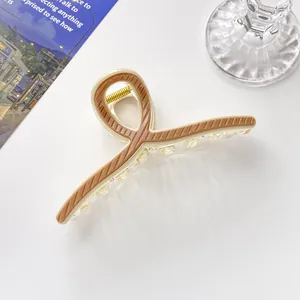 Nahaufnahme der 13 cm cremefarbenen und braun gestreiften Haarklammer mit goldener Feder