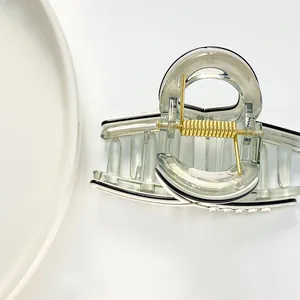 Mini pince à cheveux verte translucide avec strass et ressort doré sur fond blanc