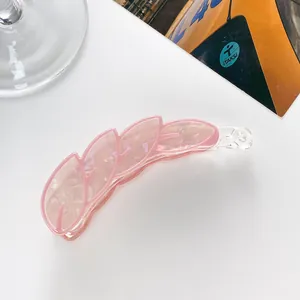 Detail of pink leaf-shaped banana hair clip with marble texture on lifestyle background