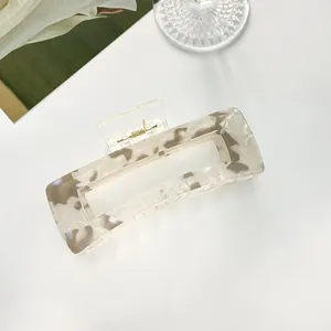 Close-up of extra large rectangular hair claw clip with beige marble acetate texture