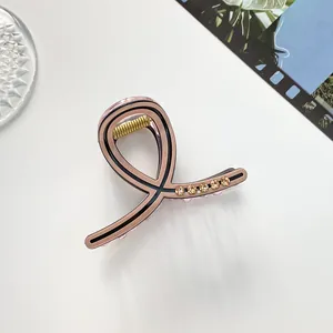 Détail de la pince à cheveux rose nude avec strass champagne et motif spirale