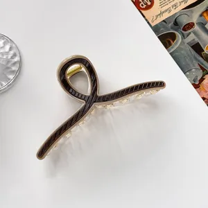 Detail der 13cm großen gestreiften Haarklammer aus zweifarbigem Harz mit Goldfeder