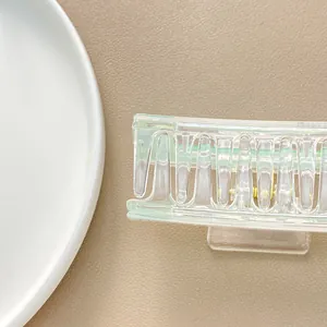 Detailed view of large transparent rectangular hair claw with mint green edge accents
