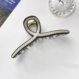 Makro-Detail einer 13cm gestreiften Haarklammer mit schwarzem Rahmen und Goldfeder