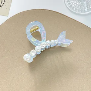Dettaglio molletta per capelli a coda di sirena con perle, strass e finitura iridescente